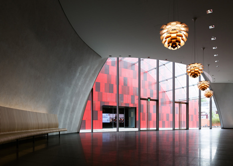Blob-shaped silver building contrasts with a red tower at Japanese music college