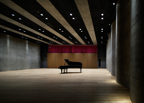 Blob-shaped silver building contrasts with a red tower at Japanese music college