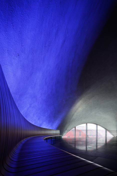 Blob-shaped silver building contrasts with a red tower at Japanese music college