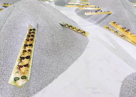 Golden girders protrude from piles of gravel to display sunglasses