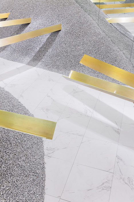 Golden girders protrude from piles of gravel to display sunglasses