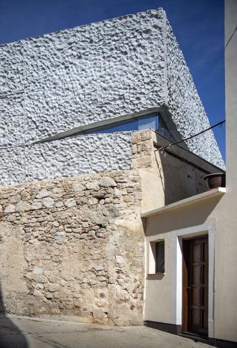 Concrete-clad sports hall by Idis Turato with both faceted and bumpy facades