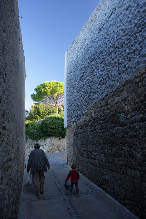 Concrete-clad sports hall by Idis Turato with both faceted and bumpy facades