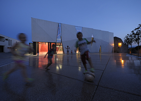 Concrete-clad sports hall by Idis Turato with both faceted and bumpy facades