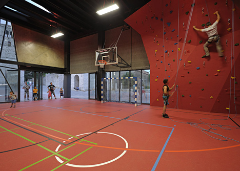 Concrete-clad sports hall by Idis Turato with both faceted and bumpy facades