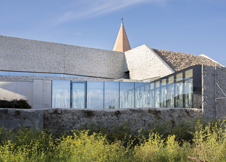 Concrete-clad sports hall by Idis Turato with both faceted and bumpy facades