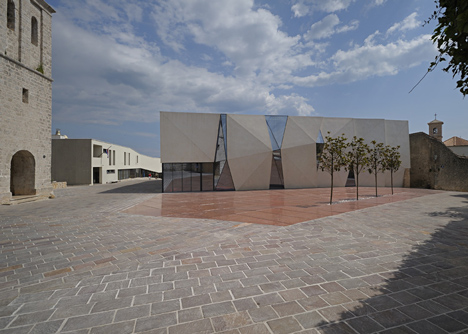 Concrete-clad sports hall by Idis Turato with both faceted and bumpy facades