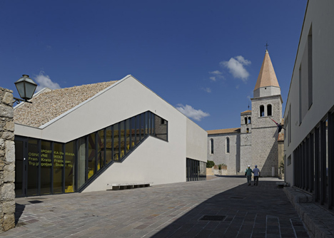 Concrete-clad sports hall by Idis Turato with both faceted and bumpy facades