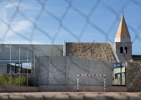 Concrete-clad sports hall by Idis Turato with both faceted and bumpy facades