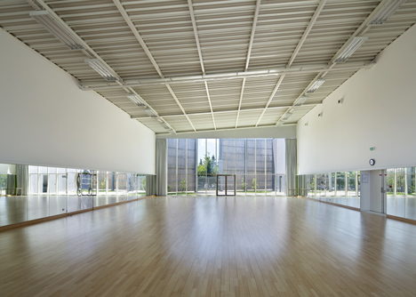 Sports centre clad with sun-bleached wooden slats by Explorations Architecture
