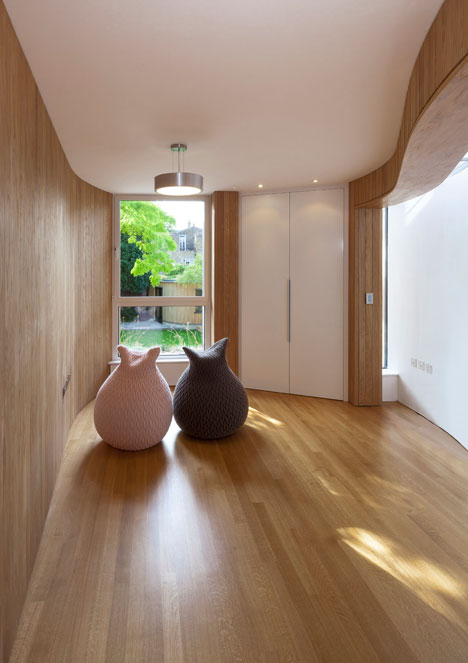 Curvy timber extension by Scott Architects features a sloping grass roof