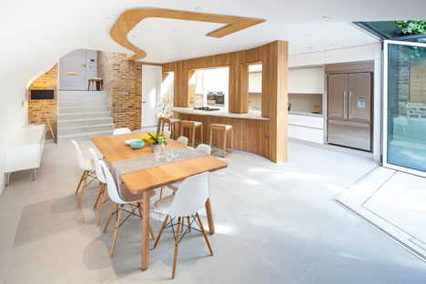 Curvy timber extension by Scott Architects features a sloping grass roof