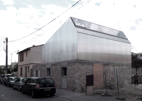 M03 house renovation by BAST contrasts old brick base with new metal extension