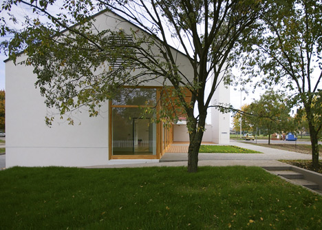 Church congregation hall by SAGRA Architects features a towering white bell tower