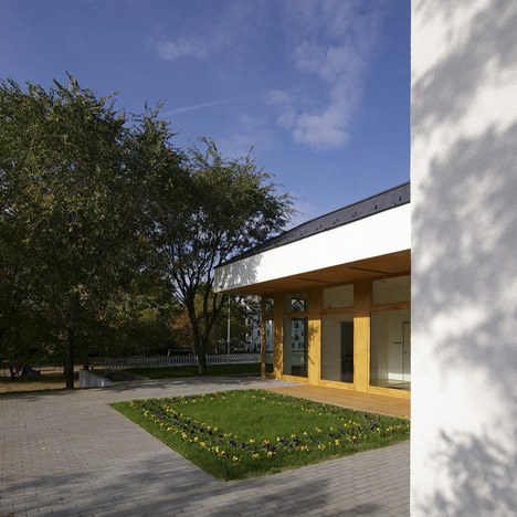 Church congregation hall by SAGRA Architects features a towering white bell tower
