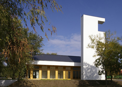 Church congregation hall by SAGRA Architects features a towering white bell tower