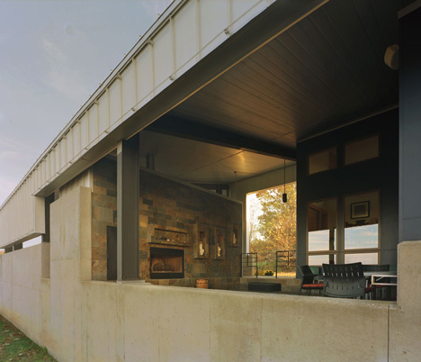 Angular metal roof wraps around a hilltop house by deMx architecture