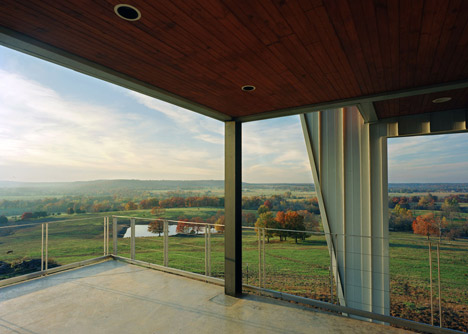 Angular metal roof wraps around a hilltop house by deMx architecture
