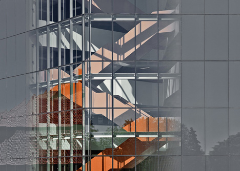 Grand orange staircase ascends through college by Saucier + Perrotte