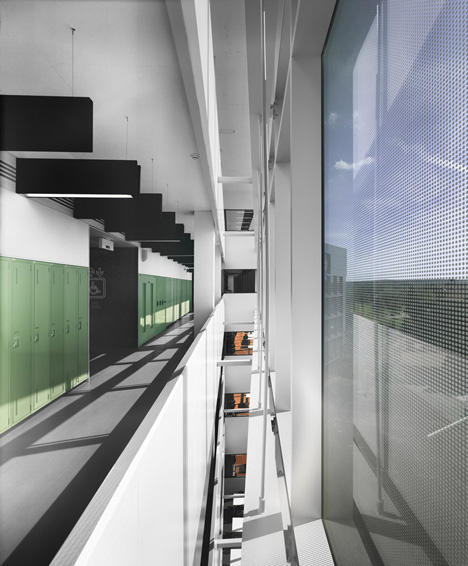 Grand orange staircase ascends through college by Saucier + Perrotte