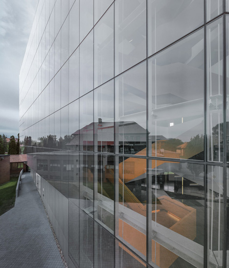 Grand orange staircase ascends through college by Saucier + Perrotte