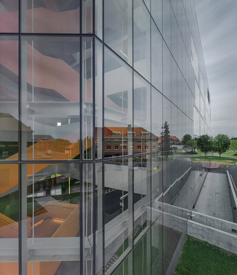 Grand orange staircase ascends through college by Saucier + Perrotte
