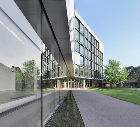Grand orange staircase ascends through college by Saucier + Perrotte