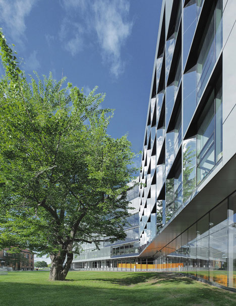 Grand orange staircase ascends through college by Saucier + Perrotte