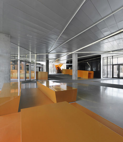 Grand orange staircase ascends through college by Saucier + Perrotte