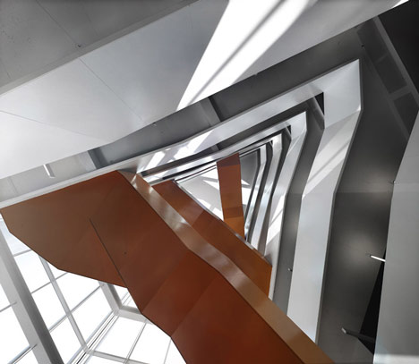 Grand orange staircase ascends through college by Saucier + Perrotte