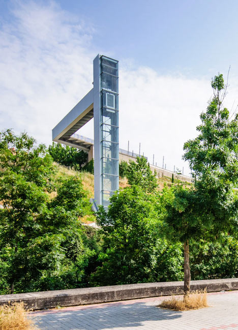 A steel-clad outdoor elevator connects the city and suburb in Pamplona by AH Asociados