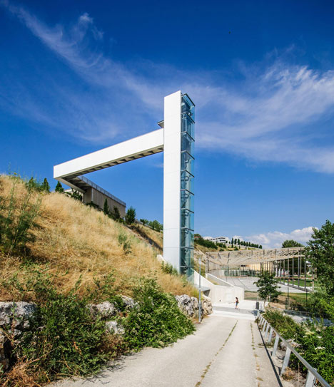 A steel-clad outdoor elevator connects the city and suburb in Pamplona by AH Asociados
