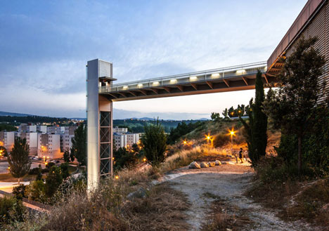 A steel-clad outdoor elevator connects the city and suburb in Pamplona by AH Asociados