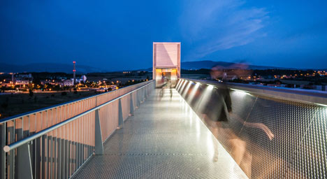 A steel-clad outdoor elevator connects the city and suburb in Pamplona by AH Asociados