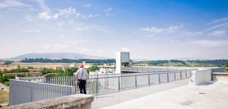 A steel-clad outdoor elevator connects the city and suburb in Pamplona by AH Asociados
