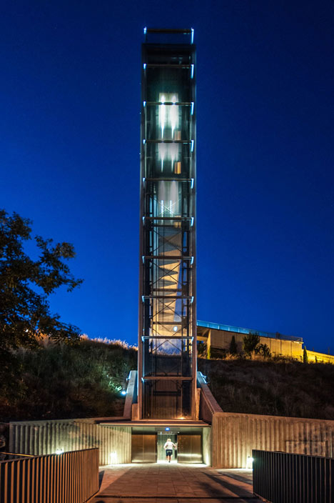 A steel-clad outdoor elevator connects the city and suburb in Pamplona by AH Asociados