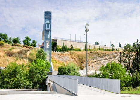 A steel-clad outdoor elevator connects the city and suburb in Pamplona by AH Asociados