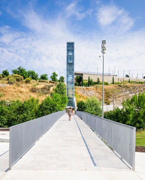 A steel-clad outdoor elevator connects the city and suburb in Pamplona by AH Asociados