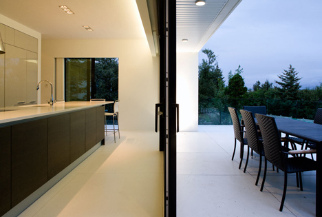 Doorway hidden in volcanic stone wall of B25 house by PK Arkitektar