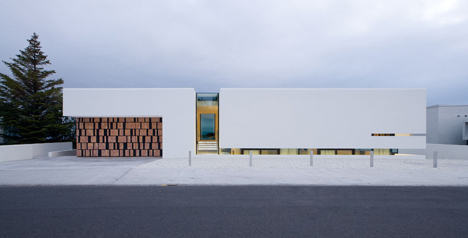 Doorway hidden in volcanic stone wall of B25 house by PK Arkitektar