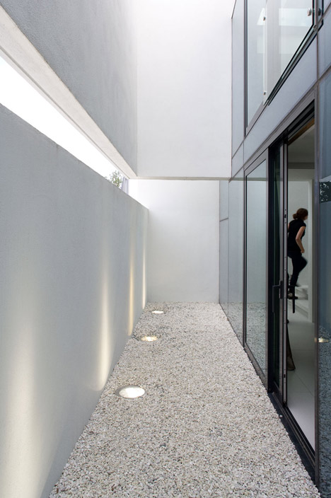 Doorway hidden in volcanic stone wall of B25 house by PK Arkitektar