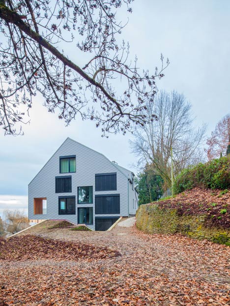 House B.A.B.E. by Destilat features windows dotted across shingle-clad facade