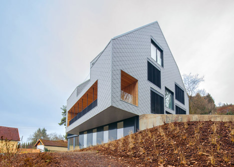 House B.A.B.E. by Destilat features windows dotted across shingle-clad facade