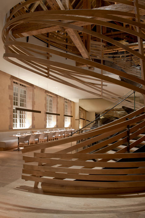 Wooden strips coil around staircase at Strasbourg hotel by Jouin Manku