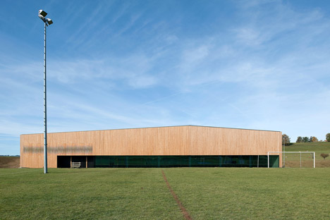 Timber walls feature narrow vertical slices at Virdis Architecture's Lussy Sports Hall