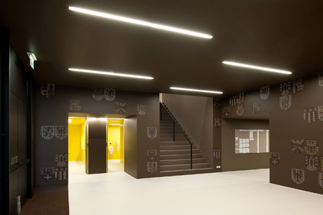 Timber walls feature narrow vertical slices at Virdis Architecture's Lussy Sports Hall