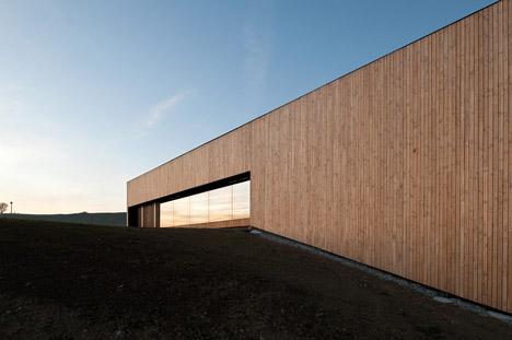 Timber walls feature narrow vertical slices at Virdis Architecture's Lussy Sports Hall