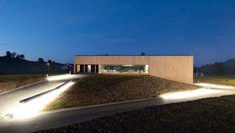 Timber walls feature narrow vertical slices at Virdis Architecture's Lussy Sports Hall
