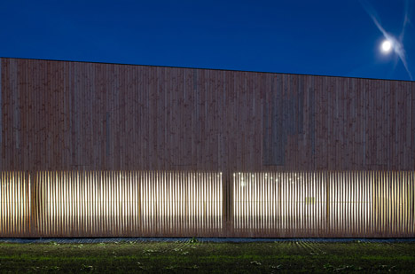 Timber walls feature narrow vertical slices at Virdis Architecture's Lussy Sports Hall