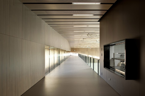 Timber walls feature narrow vertical slices at Virdis Architecture's Lussy Sports Hall